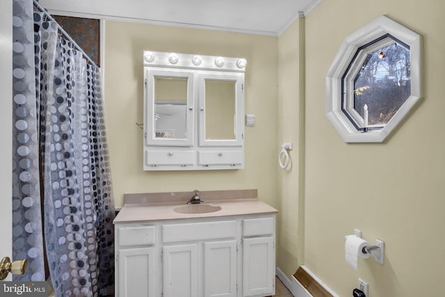 full bath featuring a shower with curtain, vanity, baseboards, and ornamental molding