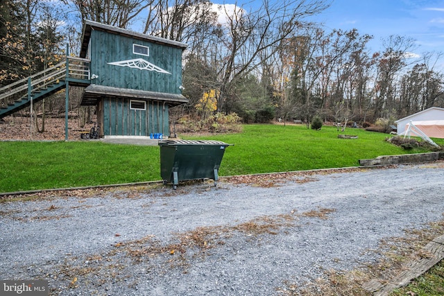 view of property exterior featuring stairway and a yard