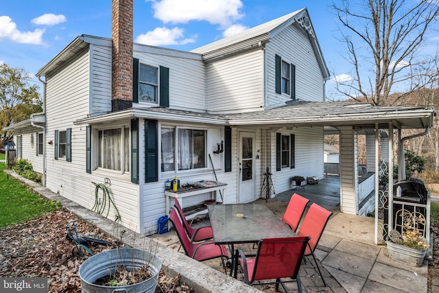 exterior space featuring a chimney and a patio area