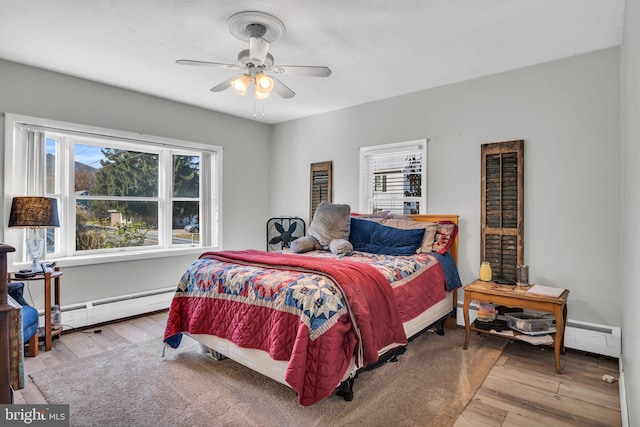 bedroom featuring hardwood / wood-style floors, ceiling fan, and a baseboard radiator