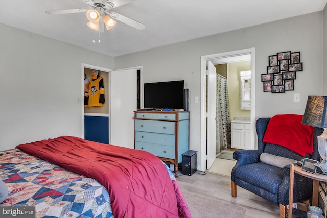 bedroom featuring a ceiling fan, light wood-type flooring, and connected bathroom