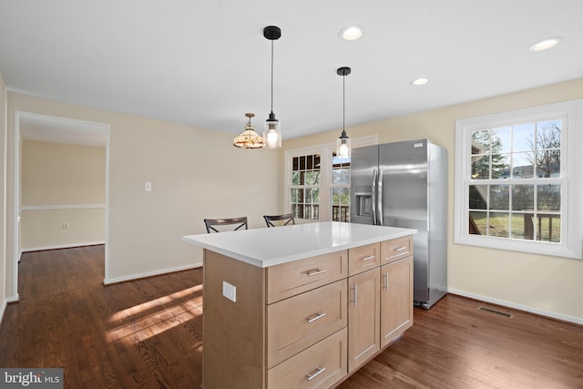 kitchen with visible vents, stainless steel refrigerator with ice dispenser, dark wood-style flooring, and a kitchen island