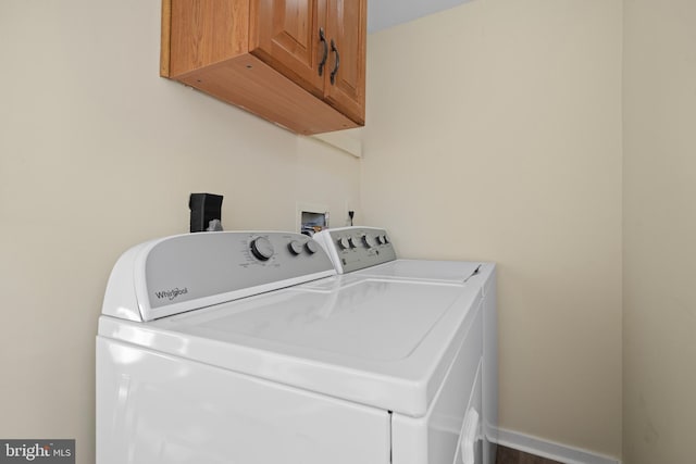 laundry room with washer and clothes dryer, cabinet space, and baseboards