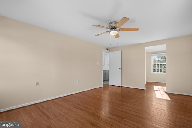 unfurnished room with baseboards, wood-type flooring, and ceiling fan