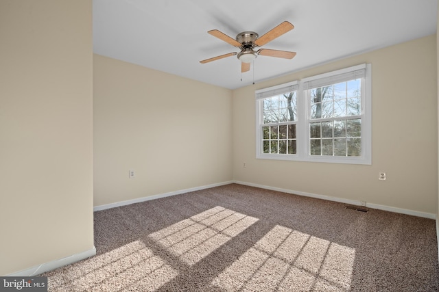 unfurnished room featuring carpet, visible vents, a ceiling fan, and baseboards