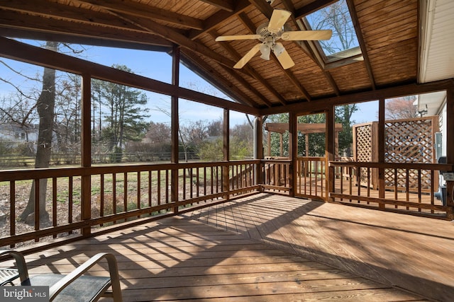 unfurnished sunroom with wood ceiling, vaulted ceiling with skylight, and a ceiling fan