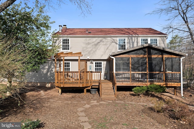 back of house with a pergola, a deck, a chimney, and a sunroom