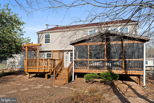 rear view of property featuring a wooden deck and a sunroom