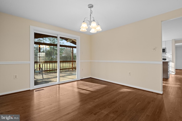 unfurnished room featuring a chandelier, visible vents, baseboards, and dark wood-style floors