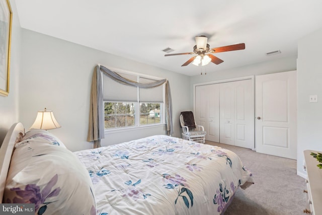 bedroom featuring a closet, visible vents, light colored carpet, and a ceiling fan