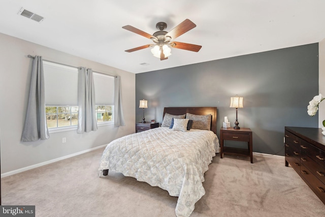 bedroom featuring visible vents, light carpet, baseboards, and a ceiling fan