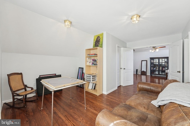 interior space with vaulted ceiling, a ceiling fan, baseboards, and wood finished floors