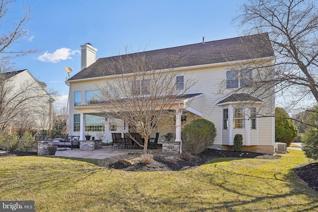 rear view of house featuring central air condition unit, a yard, a patio area, and a chimney