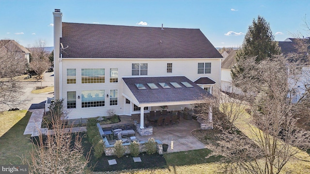 back of house with a patio and a chimney