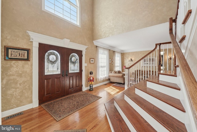 entryway featuring visible vents, stairs, baseboards, and wood finished floors