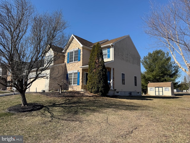 traditional-style house featuring a front lawn, a storage shed, an outdoor structure, and an attached garage