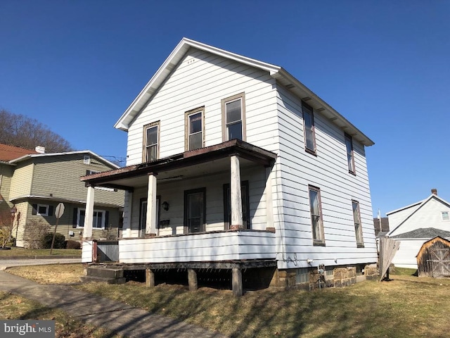 view of front of property featuring covered porch and a front lawn