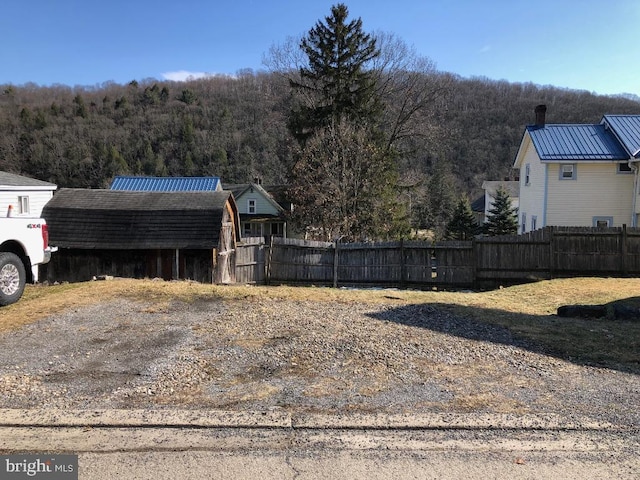 view of yard featuring a view of trees and fence