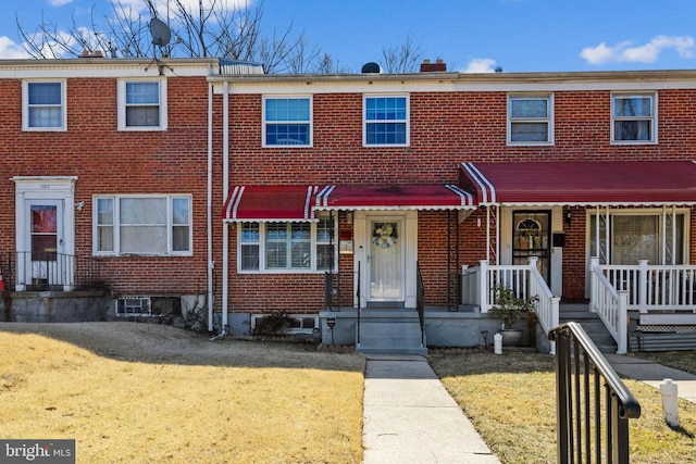 multi unit property featuring brick siding and a front yard