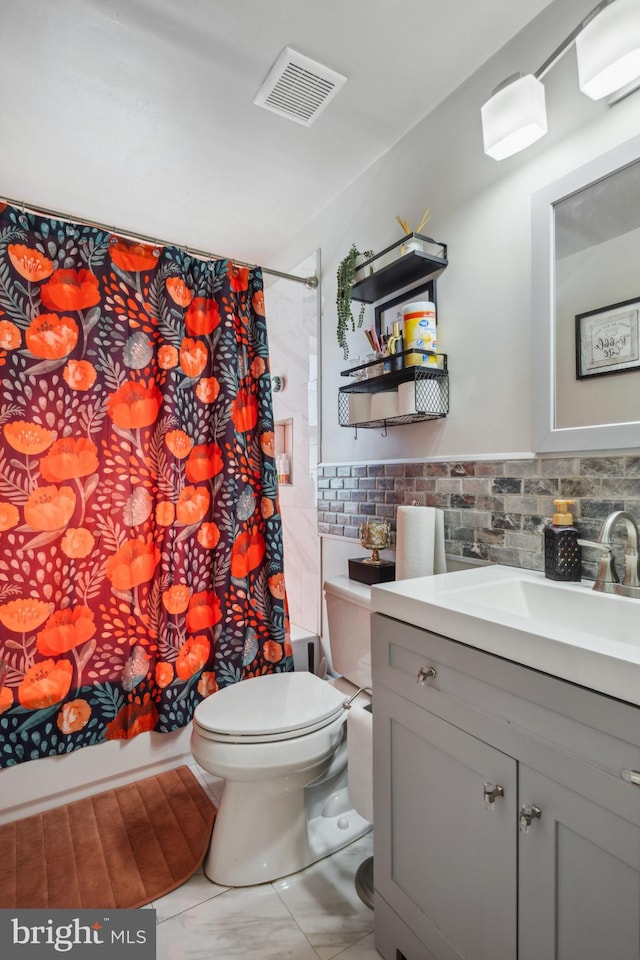 full bath with vanity, visible vents, shower / bath combo with shower curtain, tile walls, and toilet