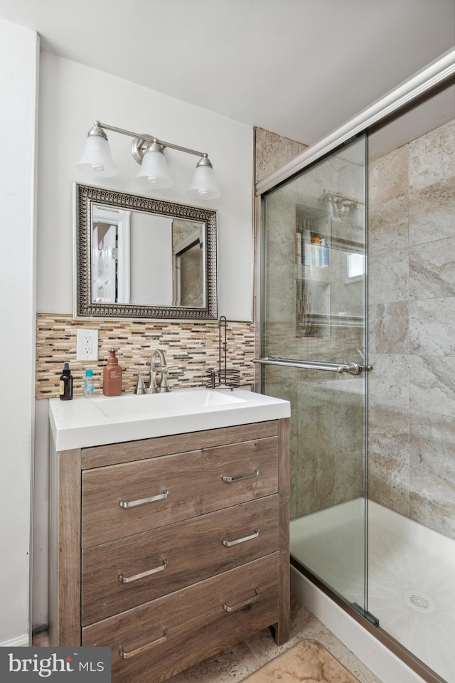 full bath with vanity, backsplash, and a shower stall