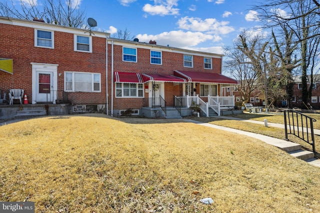 view of property with brick siding and a front lawn