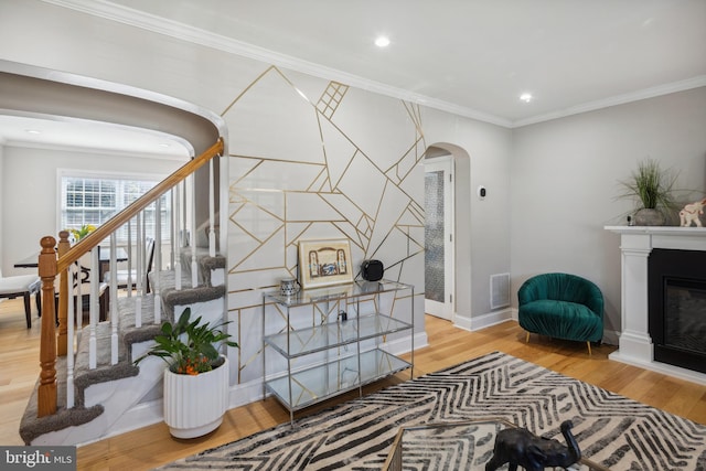 interior space featuring a glass covered fireplace, visible vents, arched walkways, and ornamental molding