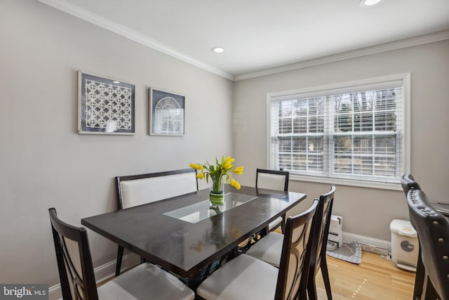 dining space featuring wood finished floors, baseboards, ornamental molding, and recessed lighting