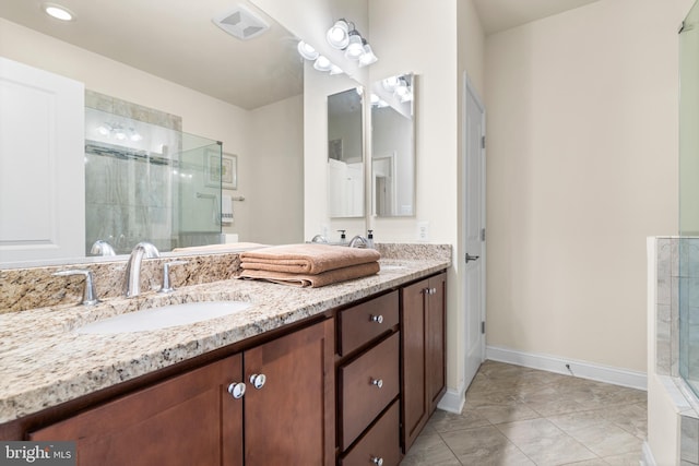 full bathroom featuring visible vents, a sink, double vanity, baseboards, and walk in shower