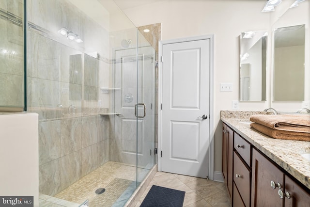 bathroom with double vanity and a shower stall