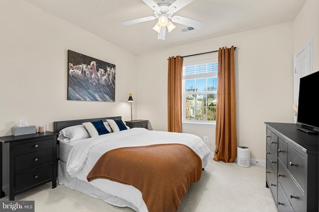 bedroom featuring baseboards, a ceiling fan, visible vents, and light carpet