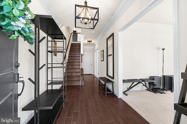 foyer entrance featuring stairs, an inviting chandelier, ornamental molding, and wood tiled floor