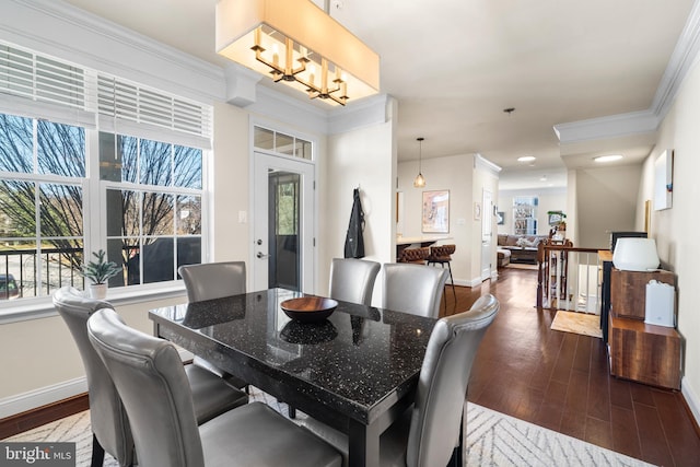 dining space with a chandelier, baseboards, ornamental molding, and dark wood-style flooring