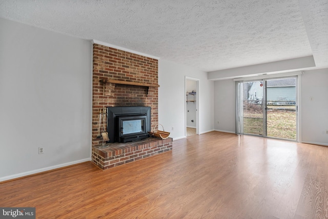 unfurnished living room featuring wood finished floors, baseboards, and a textured ceiling