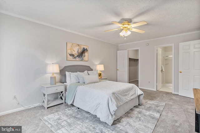 bedroom featuring a walk in closet, light carpet, a textured ceiling, and crown molding