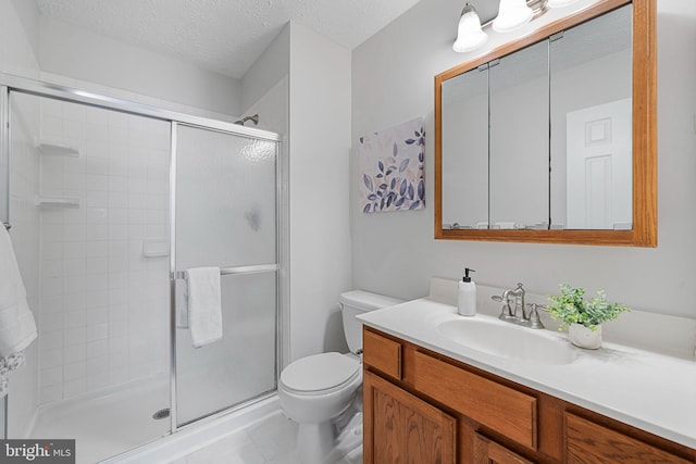 full bathroom featuring a shower stall, a textured ceiling, vanity, and toilet