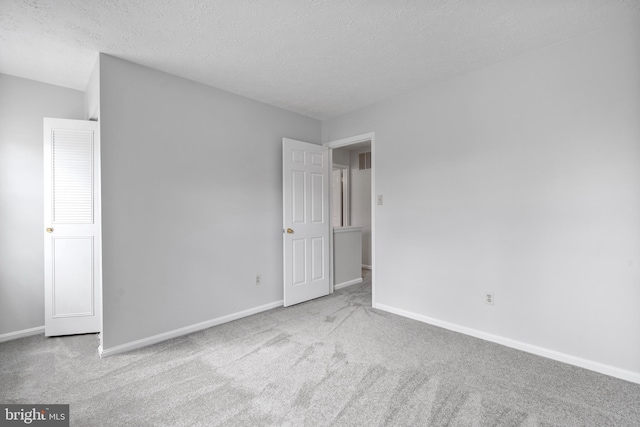 unfurnished bedroom featuring a textured ceiling, baseboards, and carpet floors