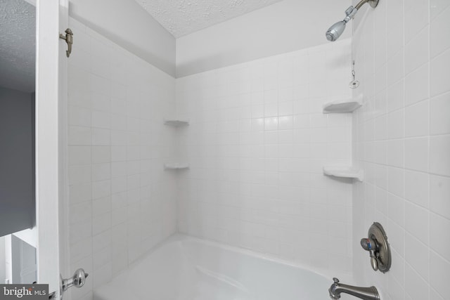 full bath featuring tub / shower combination and a textured ceiling