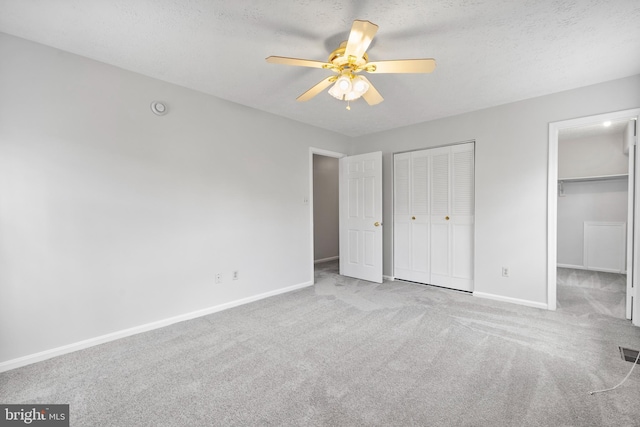 unfurnished bedroom with carpet, visible vents, baseboards, ceiling fan, and a textured ceiling