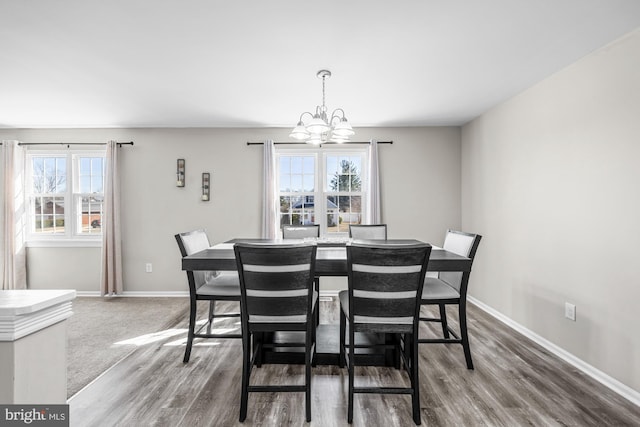 dining area featuring an inviting chandelier, baseboards, and wood finished floors