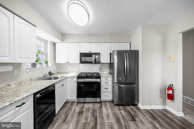 kitchen with baseboards, a sink, black appliances, white cabinets, and dark wood-type flooring