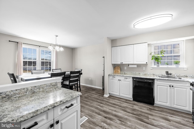 kitchen featuring dark wood finished floors, black dishwasher, hanging light fixtures, white cabinetry, and a sink