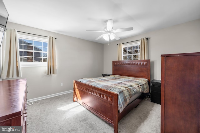 carpeted bedroom with baseboards, multiple windows, and a ceiling fan