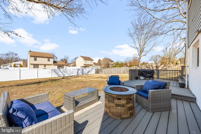 deck featuring a residential view, a lawn, an outdoor fire pit, and a fenced backyard