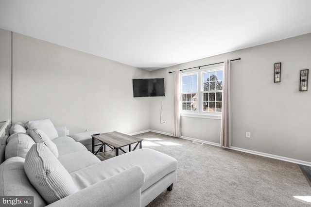 carpeted living area featuring baseboards