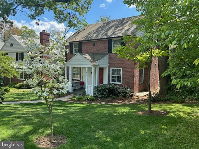 colonial-style house with a front lawn and brick siding