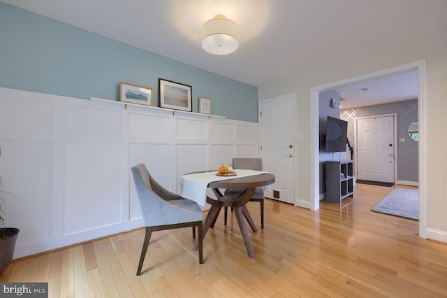 dining space featuring light wood-type flooring and baseboards