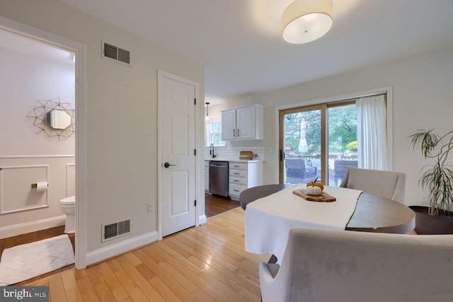 dining space featuring a wealth of natural light, visible vents, and light wood-style floors