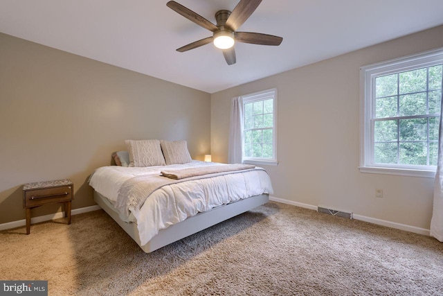 bedroom featuring visible vents, baseboards, carpet floors, and ceiling fan