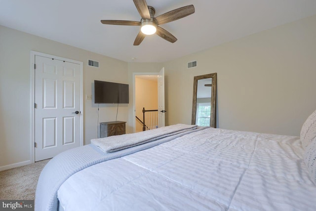 carpeted bedroom with visible vents, baseboards, and a ceiling fan